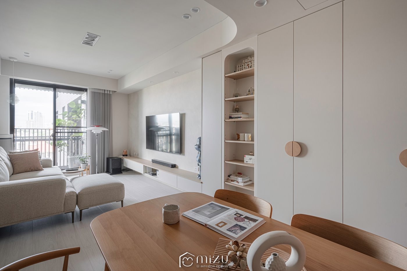 餐桌望向客廳，圓形櫃門把手與弧形天花搭配明亮淺木地坪 | GP7109 萊博淺橡 超耐磨木地板