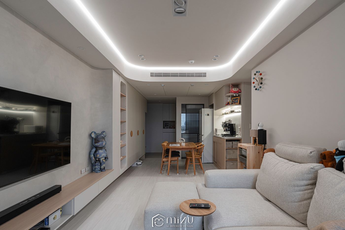 客廳沙發望向餐廳與廚房，環形間接照明搭配淺木地坪 | GP7109 萊博淺橡 超耐磨木地板