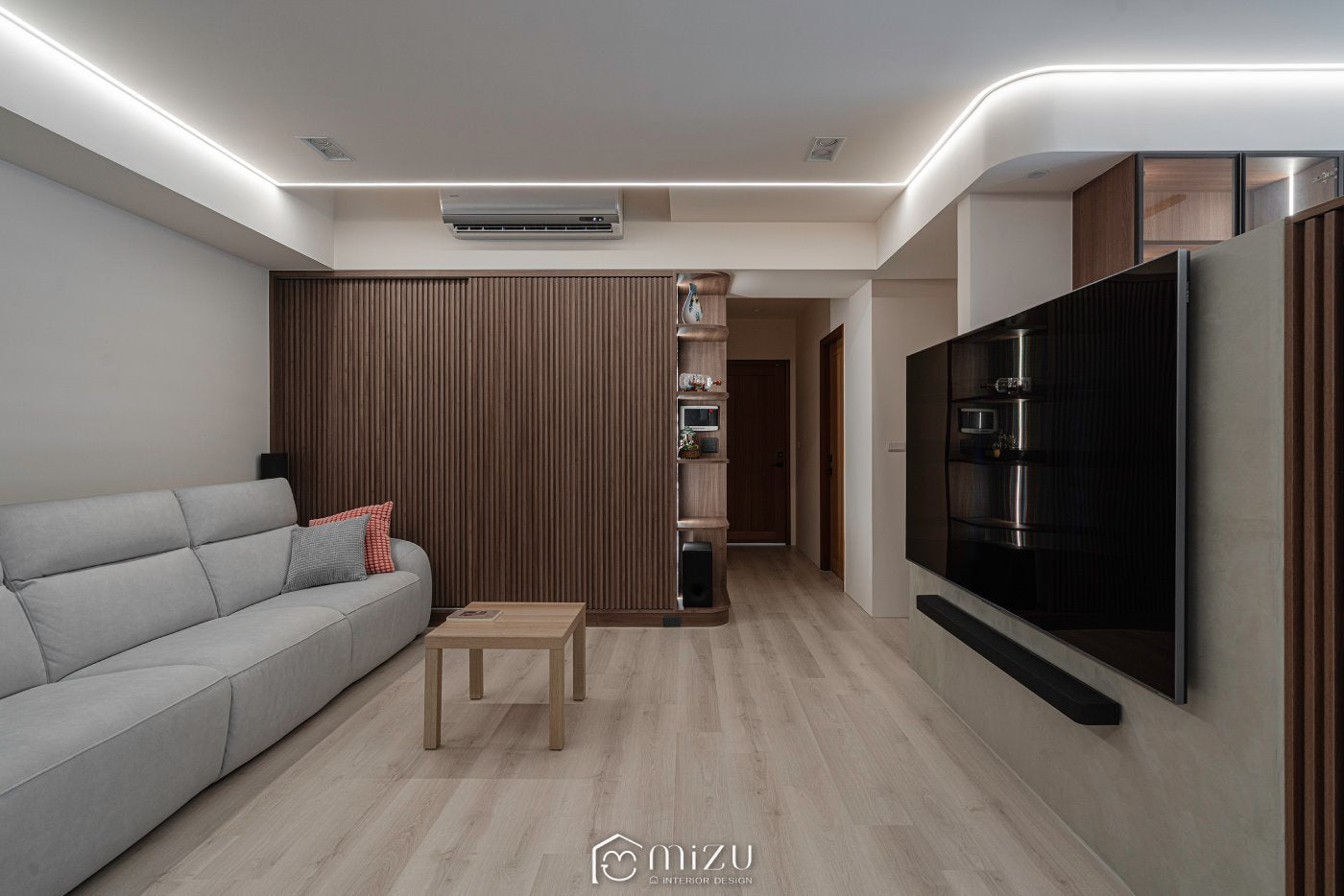 客廳全景，灰色沙發、木格柵牆與懸浮電視牆 | EHL133 科爾皮諾白橡 超耐磨木地板